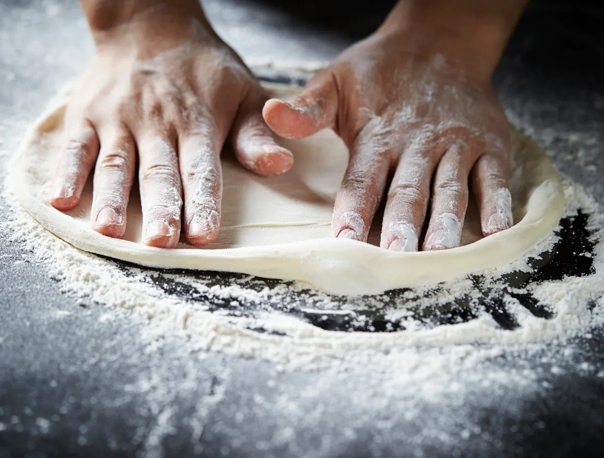 Pizzadej formes i hånden — billede fra Mona Lisas hjemmeside